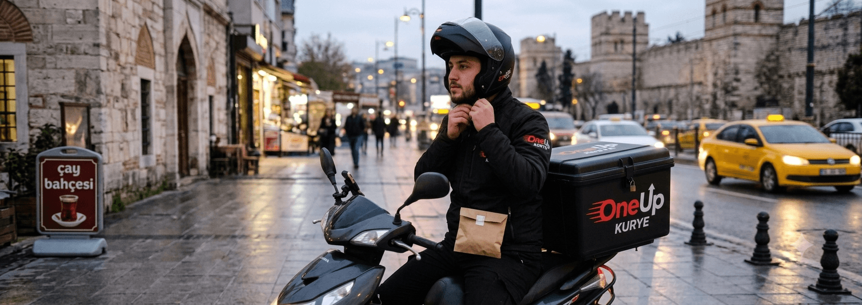 Evrak teslimatı öncesi kaskını takan OneUpKurye motokuryesi, arkasında OneUpKurye kutusu